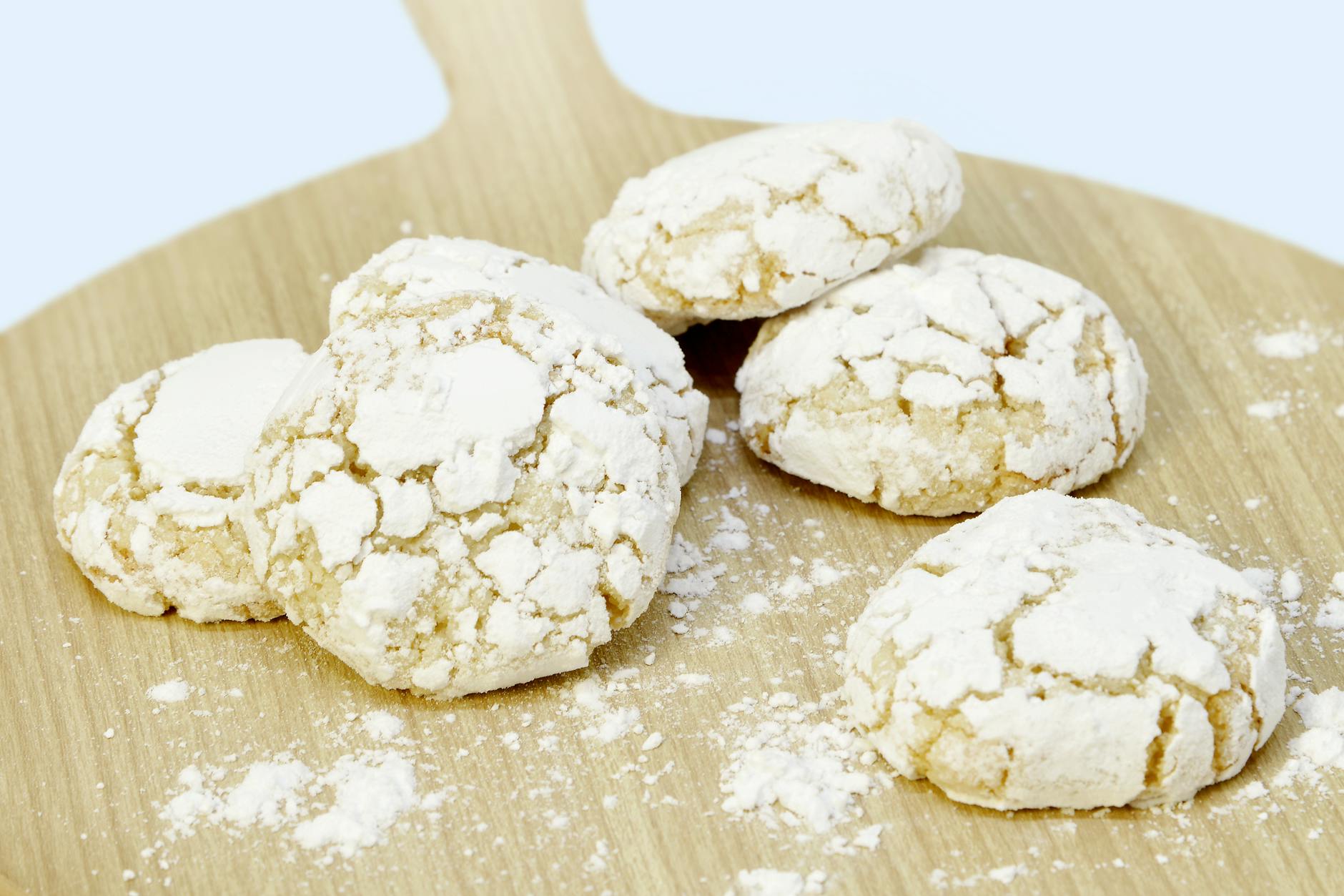 Delicious Moroccan almond cookies dusted with powdered sugar, presented on a wooden board.