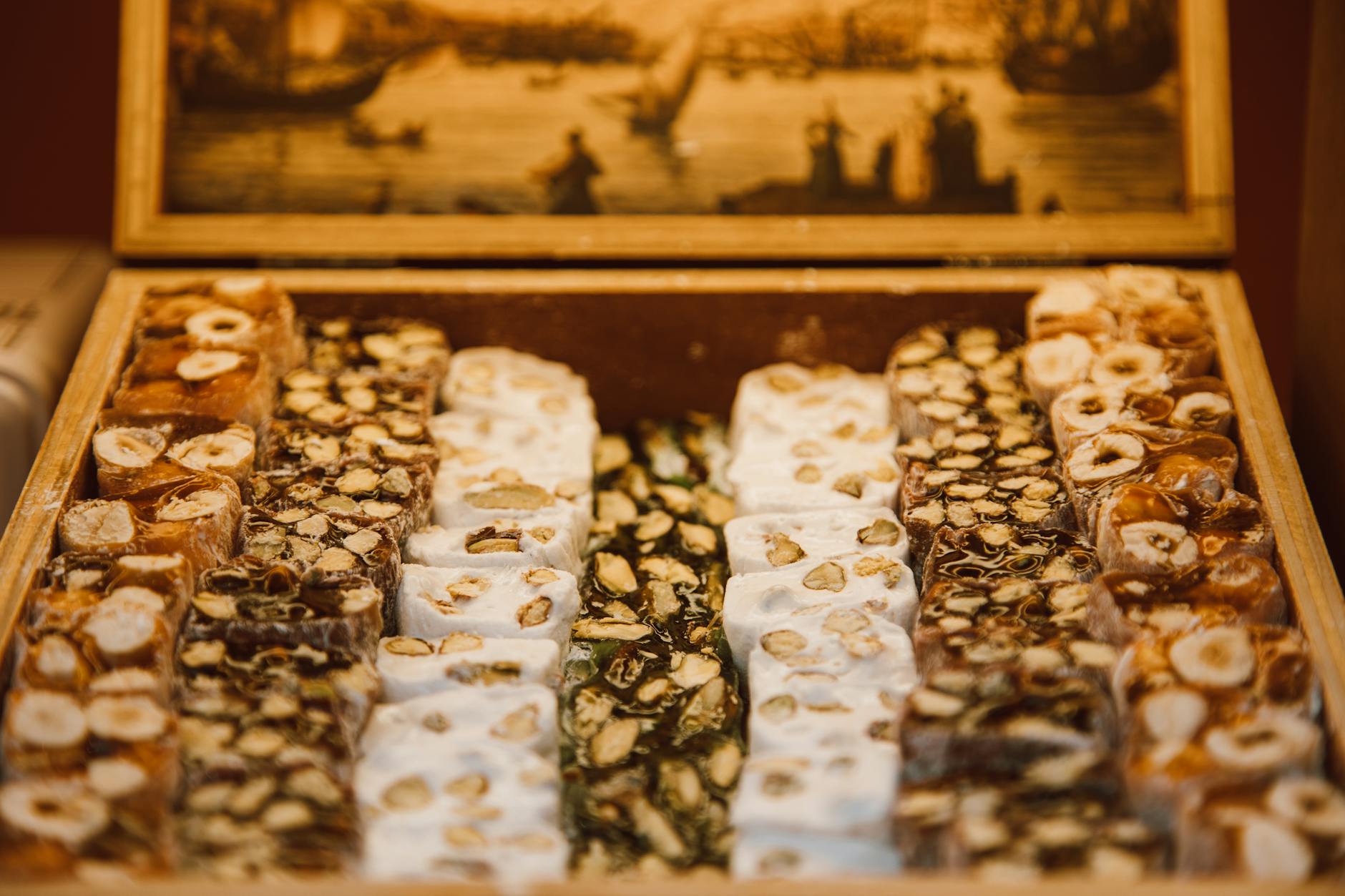 A variety of nougat flavors beautifully arranged in a rustic wooden box, perfect for dessert enthusiasts. — el turrón árabe d