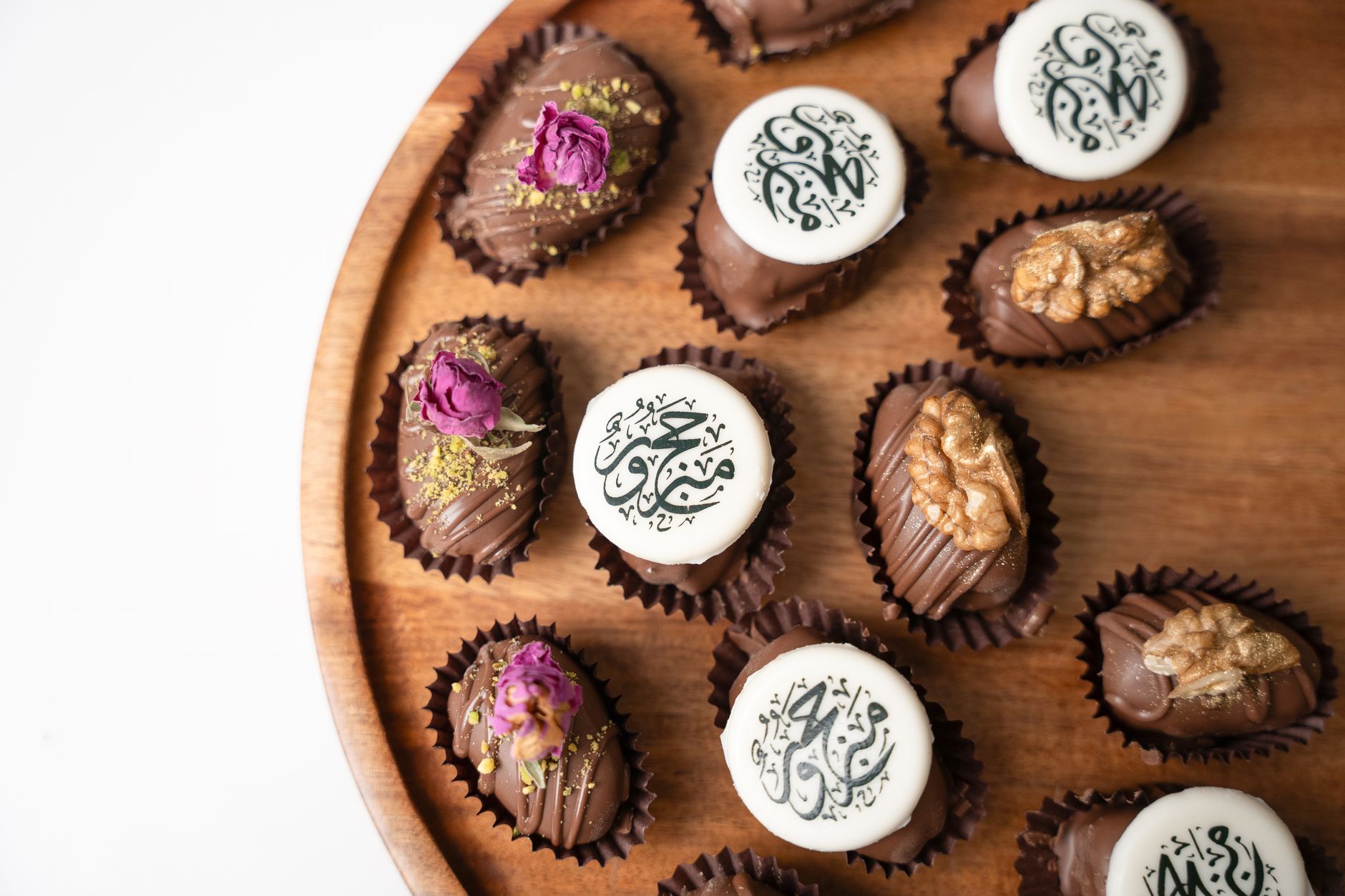 Beautifully arranged chocolate dates with Arabic calligraphy, perfect for celebrations.